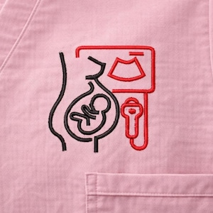 Puede incluir: Top de uniforme médico rosa con un diseño bordado. El diseño presenta un contorno negro de una persona embarazada con un feto en su interior y un ecógrafo rojo. Un bolsillo es visible en la parte inferior derecha.