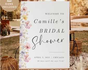 Può includere: Un cartello bianco con un bordo floreale e il testo "Benvenuti al Bridal Shower di Camille" con la data "5 aprile 2025" e la località "Chicago" e il testo "60 giorni prima che dica "Sì""