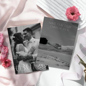 May include: Two rectangular wedding save the date cards featuring black and white photography. One card shows a couple embracing, the other shows hands holding. Text reads: SAVE OUR DATE EMMA & JACK, 03.07.26, and CHARLESTON SC.