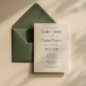 Może przedstawiać: Zaproszenie ślubne z kremową kartą i ciemnozieloną kopertą. Zaproszenie zawiera imiona Emily Carter i Daniel Hayes, datę 06.05.2026 oraz miejsca ceremonii i przyjęcia.