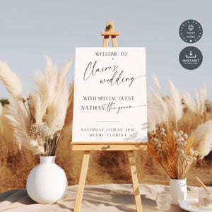Peut inclure: Une pancarte de mariage blanche avec du texte en calligraphie noire qui dit "Bienvenue au mariage de Claire avec l'invité spécial Nathan, le marié. Samedi 15 juin, Miami, Floride."