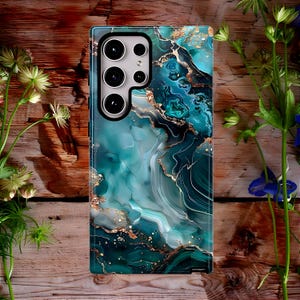 May include: A phone case with a green and gold marble design. The case has a cutout for the camera lens.