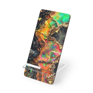 May include: A colorful phone stand with a vibrant, abstract design. The stand features a mix of orange, green, and gold tones, creating a unique, eye-catching appearance. The stand is made of a clear material and is designed to hold a phone or tablet.