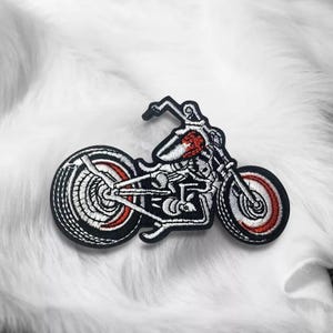 Könnte beinhalten: Ein gestickter Patch in Schwarzweiß, der ein Motorrad mit roten Akzenten zeigt. Das Motorrad hat ein detailliertes Design und ist eine großartige Ergänzung für jede Bikersammlung.