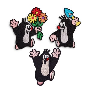 Könnte beinhalten: Drei gestickte Bügelbilder mit einem Comic-Maulwurf-Charakter. Ein Maulwurf hält einen Blumenstrauß, ein anderer eine Schaufel und der dritte lächelt mit herausgestreckter Zunge.