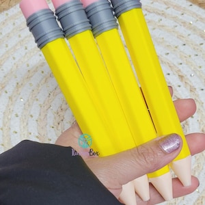May include: Four yellow pencils with hexagonal bodies, grey metal ferrules, and pink erasers at the top. The pencils have light beige conical tips at the bottom. The design features a bright yellow shaft, a textured grey band, and a smooth pink top.