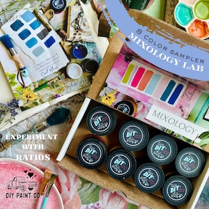 May include: A DIY Paint Co. box set with eight color samplers labeled "Mixology Lab." The box contains small black containers with the "DIY" logo, paintbrushes, and color charts. The text "Experiment with Ratios" is also visible.