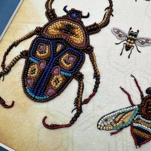 a close up of a piece of art with a bug on it