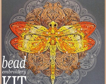 May include: A bead embroidery kit featuring a colorful dragonfly design. The dragonfly is surrounded by a mandala pattern. The kit includes all the necessary materials to create the design, including beads, thread, and needles. The text "bead embroidery KIT" is printed on the image.