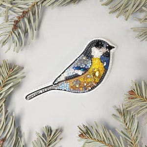 a blue bird sitting on top of a pine tree