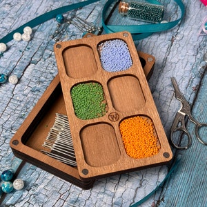 a wooden box filled with different colored beads