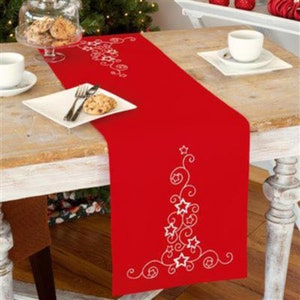 Puede incluir: Caminero de mesa rojo con un diseño bordado blanco de un árbol de Navidad con estrellas y espirales.