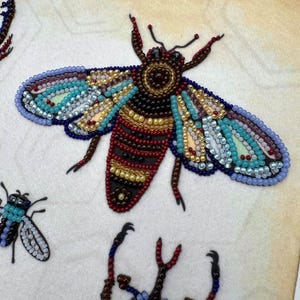 a picture of some beaded bugs on a piece of cloth