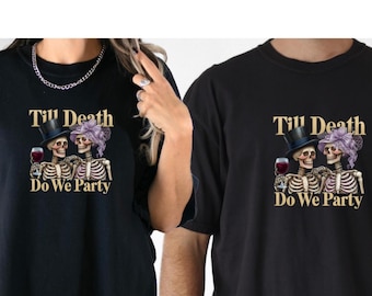 May include: Black t-shirts with a skeleton couple graphic. The skeletons wear a top hat and a purple headpiece, holding wine glasses. Text reads "Till Death Do We Party".
