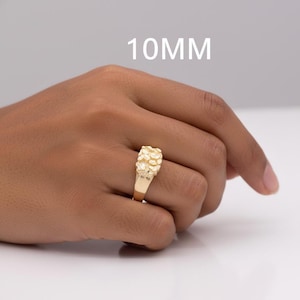 Puede incluir: Un anillo dorado con un dise&ntilde;o texturizado en forma de pepita. El anillo se muestra en una mano, con el texto "10MM" en blanco encima.