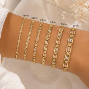 May include: Six gold bracelets of varying widths, from 1.5mm to 5.0mm, are displayed on a wrist. The bracelets feature different link designs, some with starburst and oval patterns. The gold has a polished finish, and some bracelets have tri-color accents.