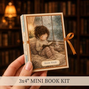 May include: A 3x4 inch mini book kit featuring a rectangular cover with an illustration of a person reading by a window with a cup of coffee. The spine and front cover are labeled Book Nook. A brown ribbon is tied to the side of the book.