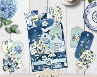 May include: A collection of paper ephemera featuring blue and white floral patterns, butterflies, and birds. The set includes a central pocket, various tags, and bookmarks with botanical illustrations and the text Where flowers bloom, so does hope.