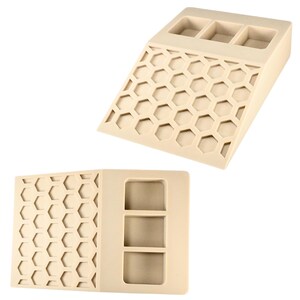 May include: Beige-colored, angled organizer with three rectangular compartments at the top and a honeycomb pattern on the front. The organizer is made of a solid material and is designed to hold small items.