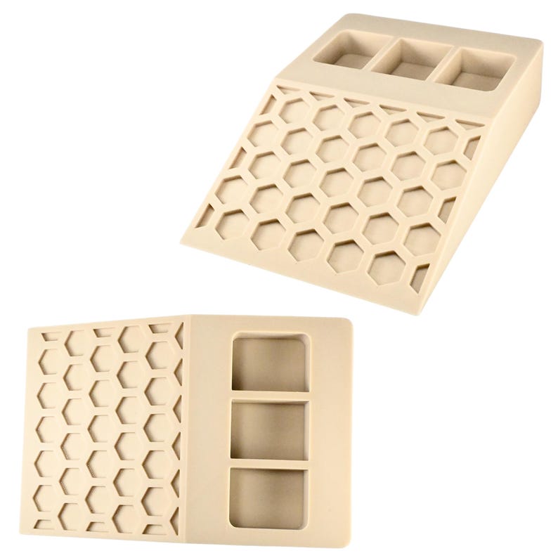 May include: Beige-colored, angled organizer with three rectangular compartments at the top and a honeycomb pattern on the front. The organizer is made of a solid material and is designed to hold small items.