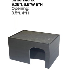 May include: Black plastic reptile hide with a flat, gray, textured roof. Dimensions: 9.25"L 6.5"W 5"H. Opening: 3.5"L 4"H.