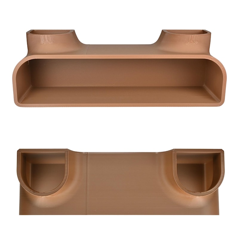 May include: A two-piece, brown, rectangular shelf unit with rounded corners and two raised end sections. The shelf has a long, open compartment and is designed for wall mounting. The unit is made of a solid, smooth material.