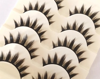 May include: Six pairs of black false eyelashes packaged on a white card with the text "F56" printed on the bottom.