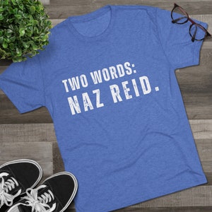 May include: A blue t-shirt with white text that reads "TWO WORDS: NAZ REID."