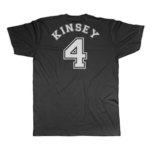 Puede incluir: Camiseta negra con texto blanco que dice "Kinsey 4" en la espalda.