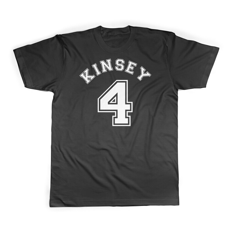 Puede incluir: Camiseta negra con texto blanco que dice "Kinsey 4" en una fuente de estilo universitario.