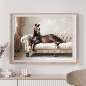 May include: A brown horse lying on a beige tufted sofa with a beige background. The horse is looking to the left of the frame.