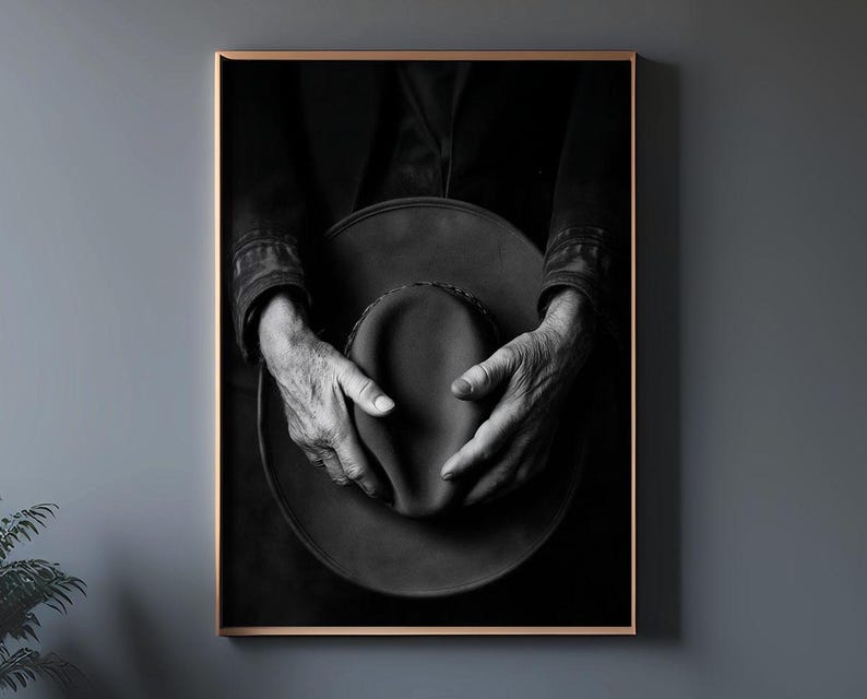 Pu&ograve; includere: Una fotografia in bianco e nero di mani che tengono un cappello a tesa larga. Il cappello &egrave; fatto di un materiale scuro e ha una superficie leggermente strutturata. Le mani della persona sono visibili nell'immagine e stanno tenendo il cappello in un modo che suggerisce che stanno per metterlo in testa.
