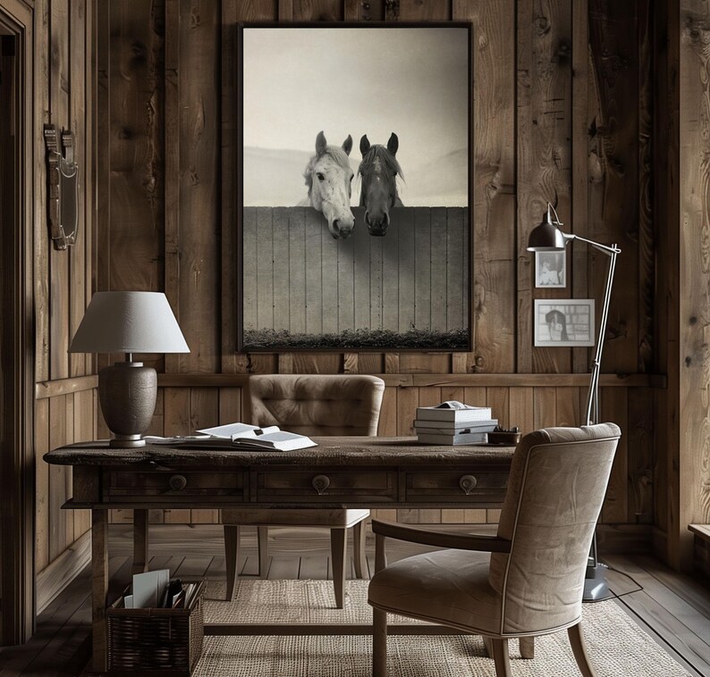 Pu&ograve; includere: Un ufficio in legno rustico con una grande fotografia in bianco e nero incorniciata di due cavalli bianchi che guardano oltre una recinzione. L'ufficio &egrave; dotato di una scrivania in legno con una lampada, una sedia e un archivio.