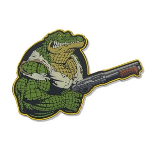 Peut inclure: Un alligator vert musclé, portant une chemise blanche, tient un fusil de chasse dans sa main droite. L'alligator a un contour jaune et est sur un fond noir.