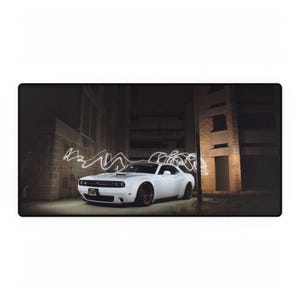 May include: A white Dodge Challenger muscle car parked in an urban setting at night. The car is illuminated by white light streaks, creating a dynamic effect.