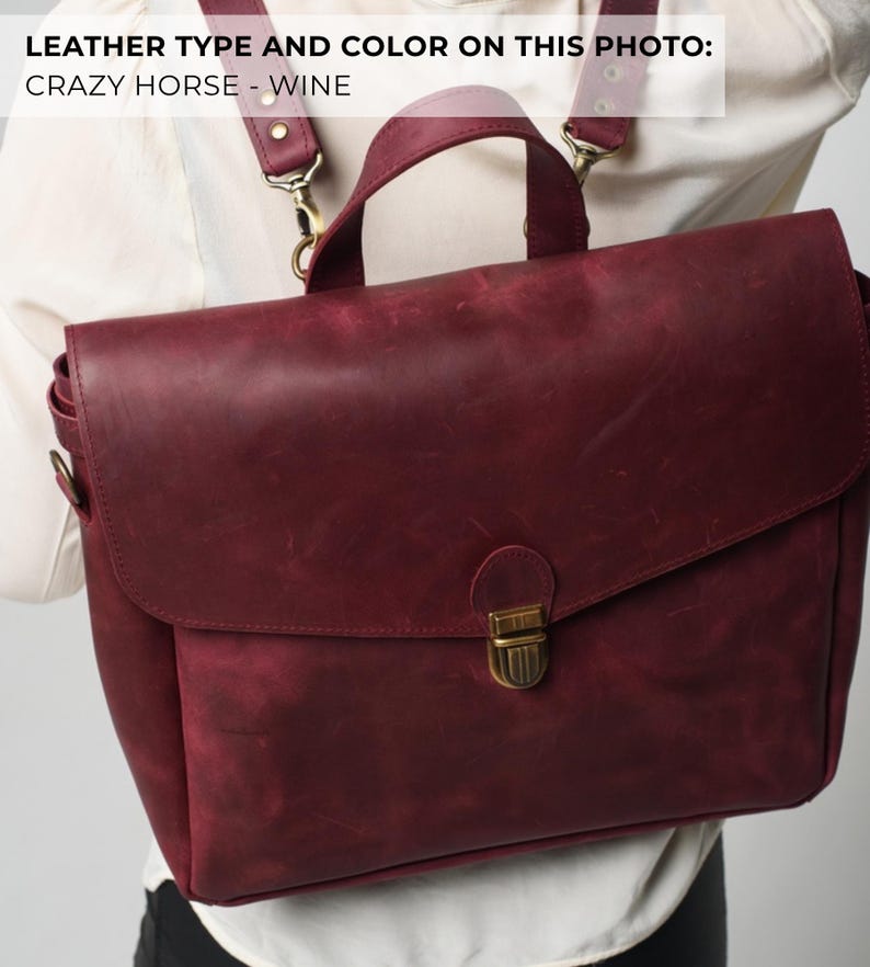 May include: A burgundy leather satchel with a flap closure and a top handle. The bag has adjustable shoulder straps and a brass-coloured clasp. The leather has a distressed appearance, and the image text reads "LEATHER TYPE AND COLOR ON THIS PHOTO: CRAZY HORSE - WINE."