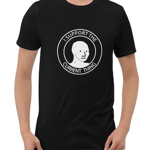 May include: A black t-shirt with a white circle graphic featuring a stick figure with a blank face and the text "I Support The Current Thing".