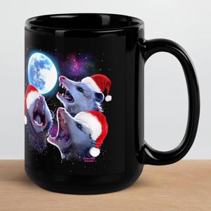 May include: Black ceramic mug with a graphic of three possums wearing Santa hats and howling at the moon. The moon is blue and the background is a starry night sky. The text "Gravity Coast" is printed on the bottom of the mug.
