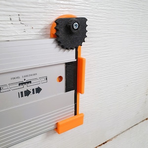 May include: A close-up of a silver and orange measuring tool with a black gear and a white label that reads "FSN VEL 1 600 200 009".