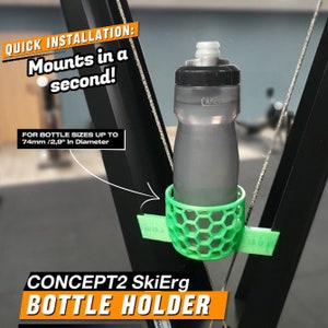 May include: Green plastic water bottle holder for a Concept2 SkiErg. The holder is designed to fit water bottles up to 2.9 inches in diameter.  The text "QUICK INSTALLATION: Mounts in a second!" is visible in the image.  The text "FOR BOTTLE SIZES UP TO 74mm/2.9" in Diameter" is also visible in the image.