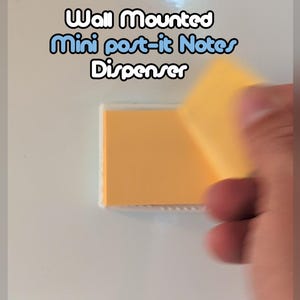 May include: A wall-mounted mini Post-it Notes dispenser. The dispenser is white and contains a pad of yellow sticky notes. The text "Wall Mounted Mini post-it Notes Dispenser" is displayed above the dispenser.