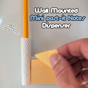 Könnte beinhalten: Ein wandmontierter Mini-Post-it-Notizblock-Spender mit Stifthalter. Der Spender ist weiß und enthält einen Block gelber Haftnotizen. Ein gelber Bleistift befindet sich im Stifthalter. Der Text auf dem Bild lautet "Wall Mounted Mini post-it Notes Dispenser with Penstand."