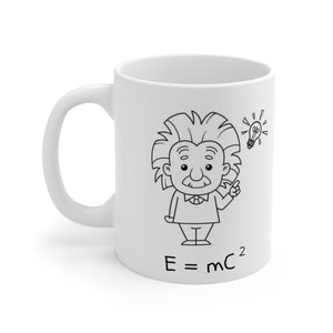 Könnte beinhalten: Weiße Keramiktasse mit einer Cartoon-Illustration von Albert Einstein, einer Glühbirne und der Gleichung E=mc². Das schwarz-weiße Design ist auf die Seite der Tasse gedruckt, die einen gebogenen Griff hat.
