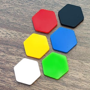 May include: Six hexagonal game pieces in different colors: red, black, yellow, blue, green, and white. The pieces are arranged in a circle on a wooden surface.
