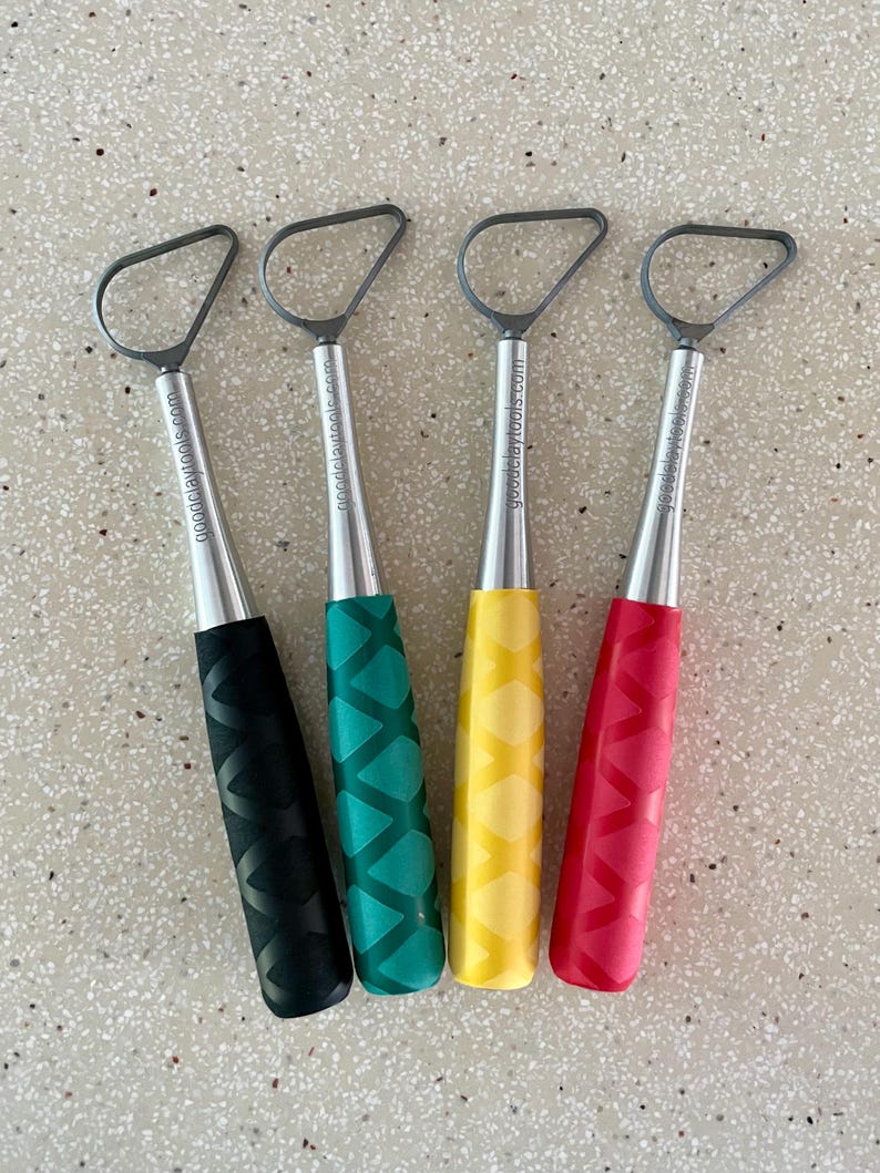 May include: Four metal sculpting tools with different colored handles. The handles are black, green, yellow, and red. Each tool has a loop at the top and the words "goodeclaytools.com" are printed on the side of each tool.