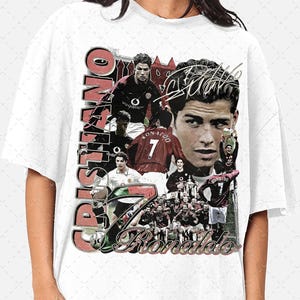 May include: A white t-shirt with a collage of images of Cristiano Ronaldo playing soccer for Manchester United. The images include Ronaldo wearing the number 7 jersey, celebrating goals, and holding trophies. The text "Cristiano Ronaldo" is written in red and white letters on the shirt.