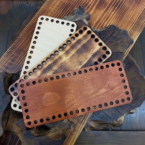 Puede incluir: Tres tablas de tejido de telar de madera en diferentes tonos de marrón. Las tablas son rectangulares con esquinas redondeadas y tienen una serie de agujeros alrededor de los bordes.