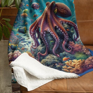 May include: A plush throw blanket featuring a vibrant underwater scene with a large purple octopus resting on a coral reef. The design includes various colorful tropical fish swimming among detailed coral formations in shades of blue, orange, and pink.