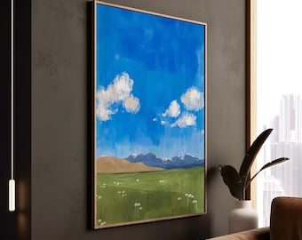 May include: A framed landscape painting with a blue sky, white clouds, and a green field with mountains in the distance.