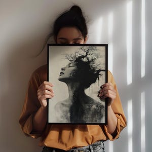 a woman holding up a picture of a tree